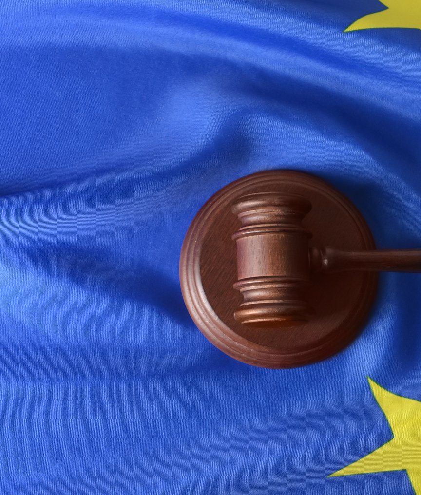 Wooden gavel on the EU flag representing European Union legislation, regulatory compliance, and cour