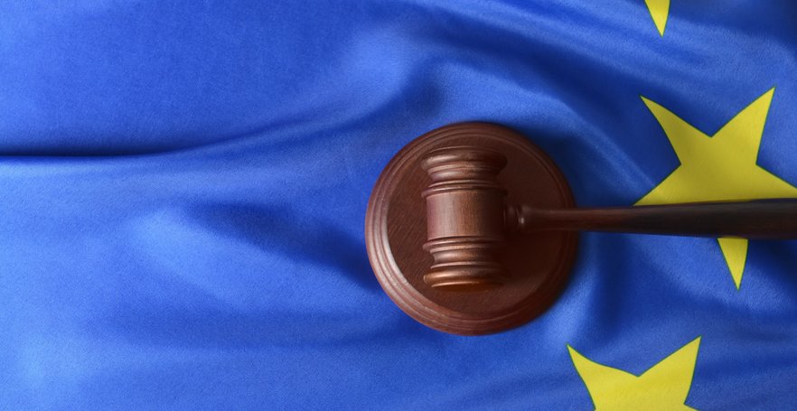Wooden gavel on the EU flag representing European Union legislation, regulatory compliance, and cour