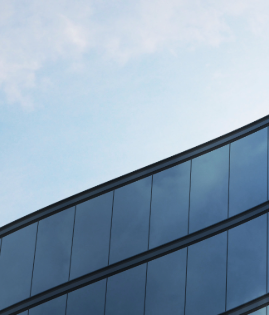 Modern curved glass building reflecting the sky