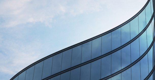 Modern curved glass building reflecting the sky