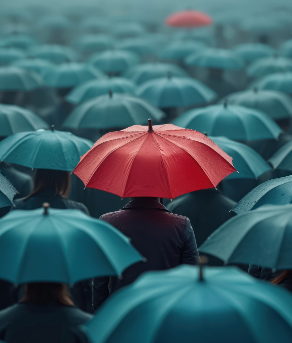 Grey umbrellas with one red umbrella standing out